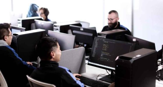 Jóvenes revisando la oferta de programas virtuales del SENA en un ordenador.