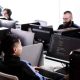 Jóvenes revisando la oferta de programas virtuales del SENA en un ordenador.