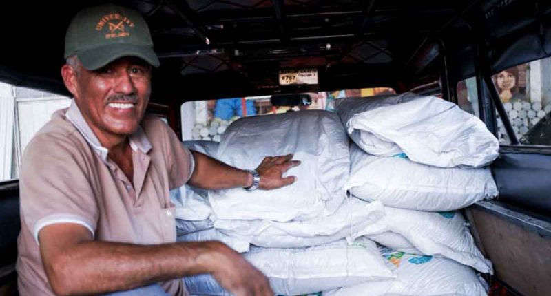Productores agropecuarios recibiendo sacos de fertilizante orgánico en el municipio de Villeta.