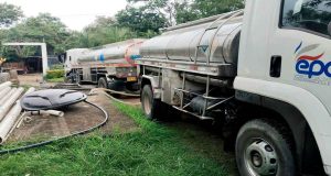 Operarios de Empresas Públicas de Cundinamarca distribuyen agua potable mediante carrotanques a familias afectadas por la temporada seca.